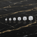 Moissanite Stud Earrings in 3mm, 4mm, 5mm, 6mm, 7mm, and 8mm sizes on a black marble surface