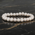 White Genuine Fresh Water Pearl Stretch Bracelet for Women on a dark marble surface