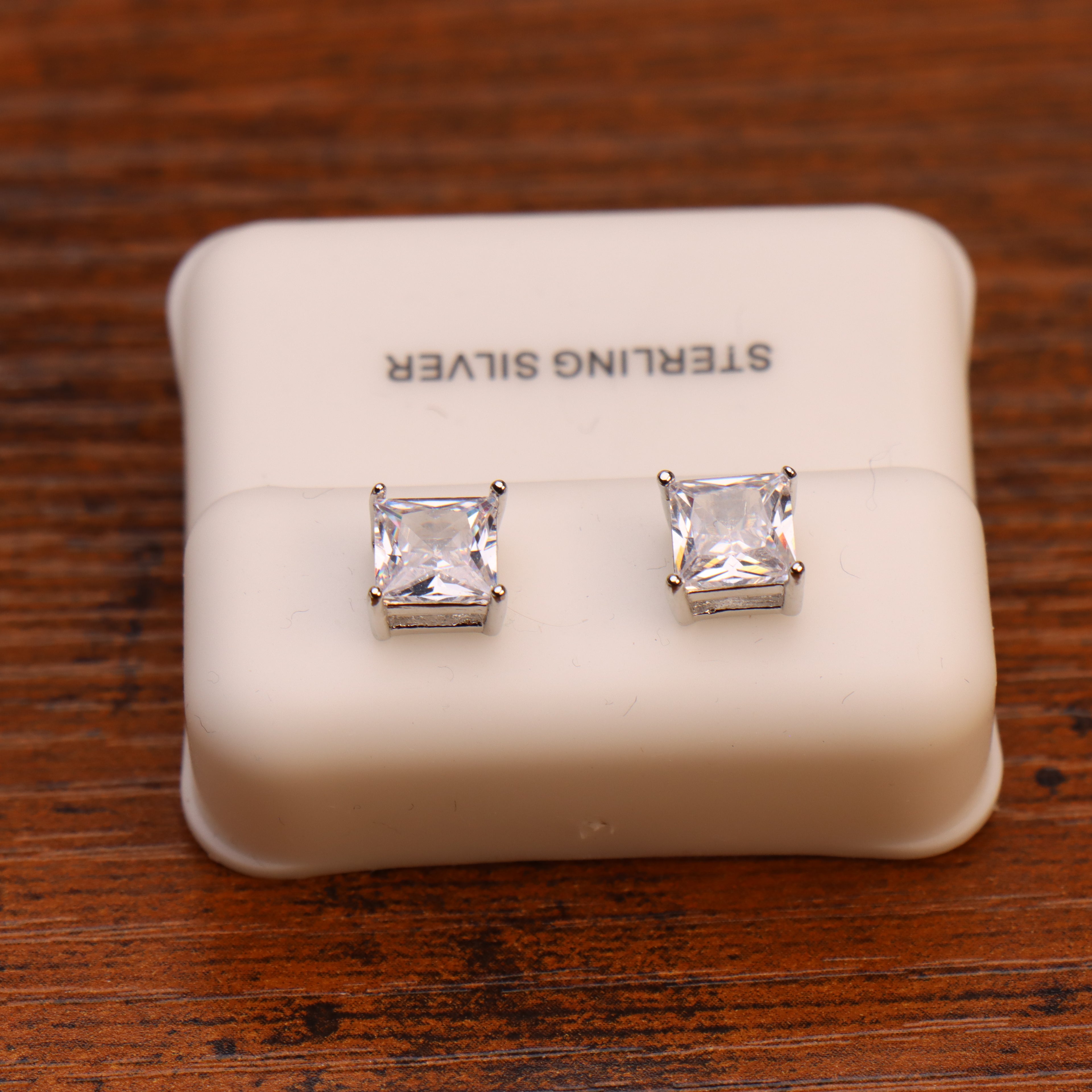 Clear CZ square princess cut 925 sterling silver earrings on a white display