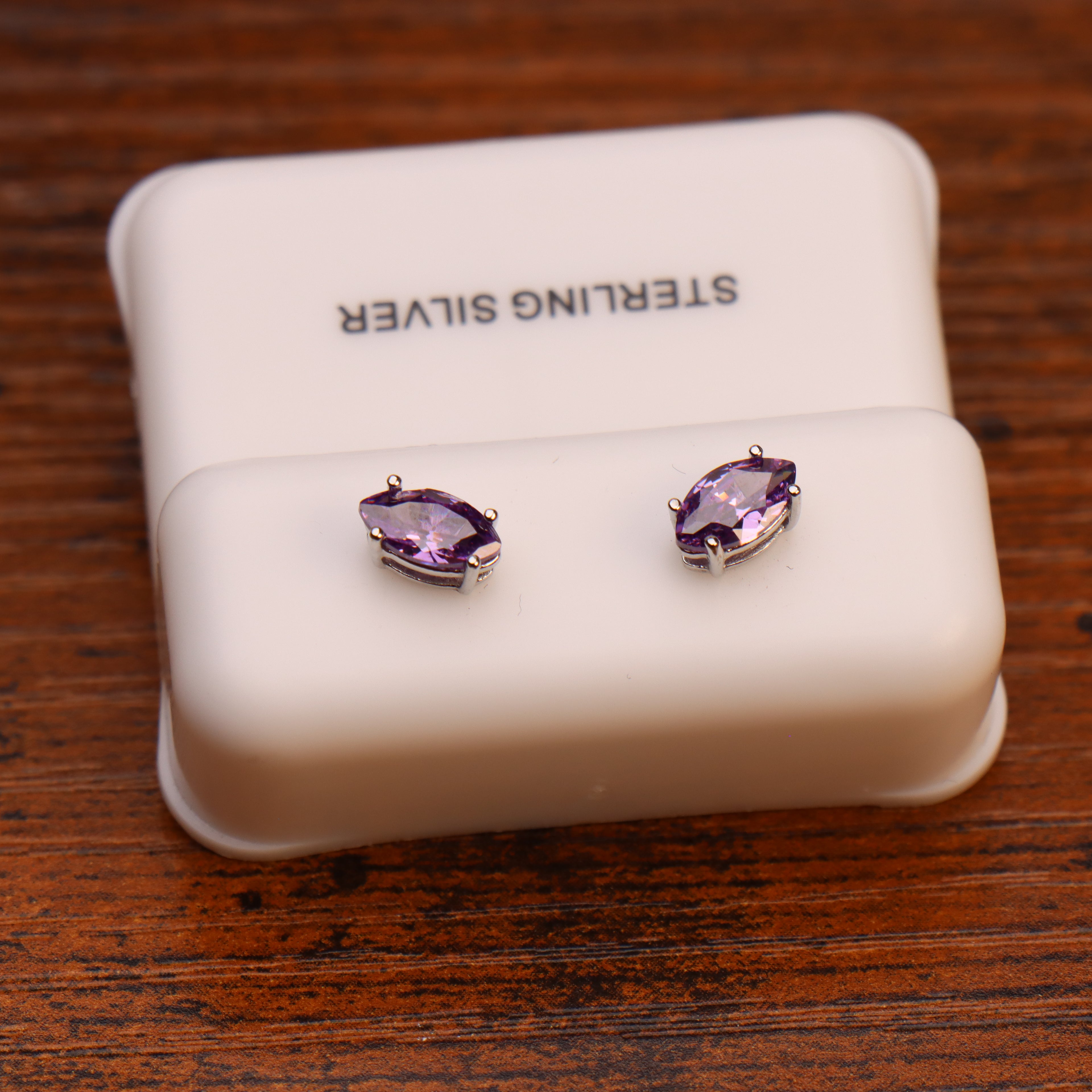 Marquise purple CZ stud earrings in 925 sterling silver on a white display box