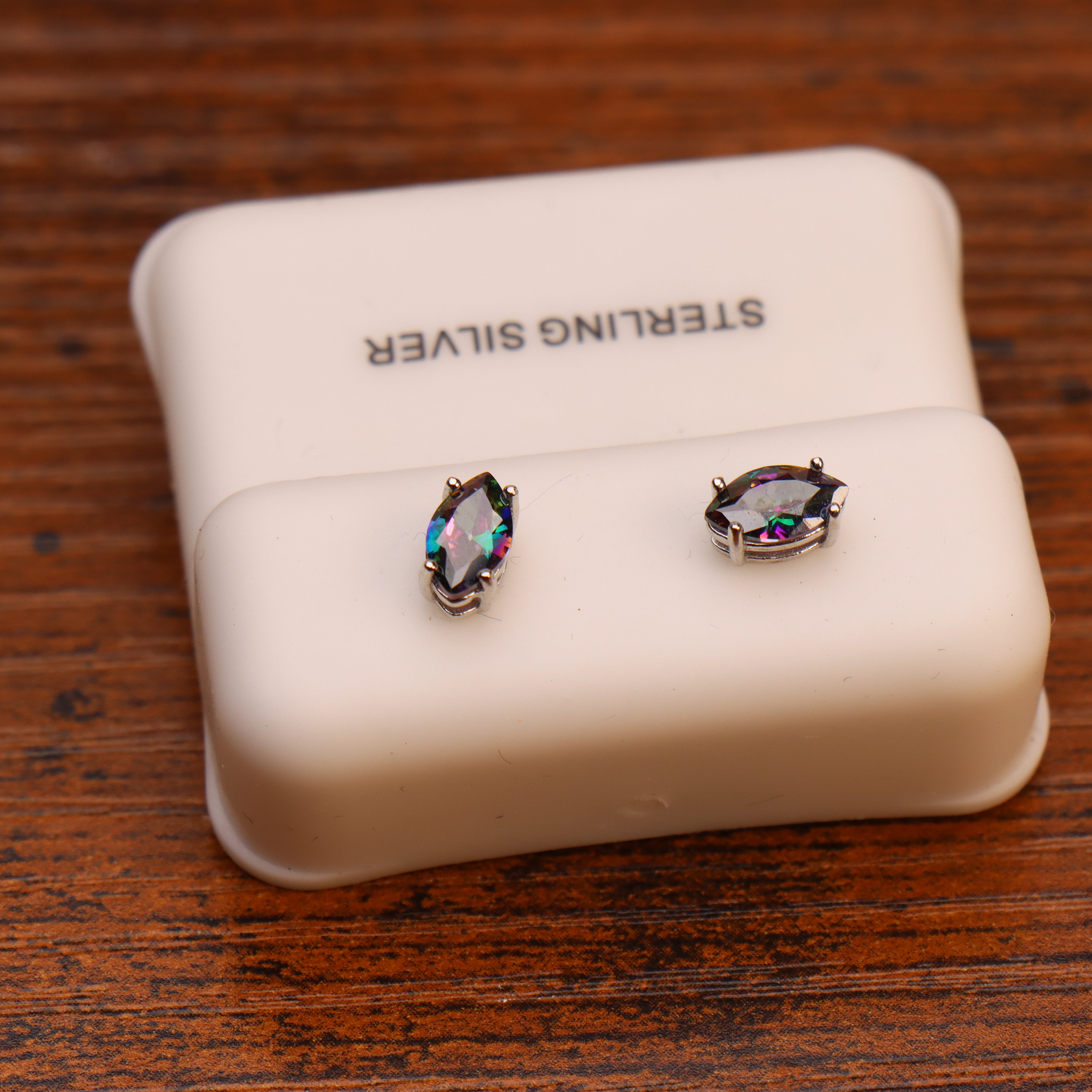 Marquise mystic topaz sterling silver stud earrings on a white display stand