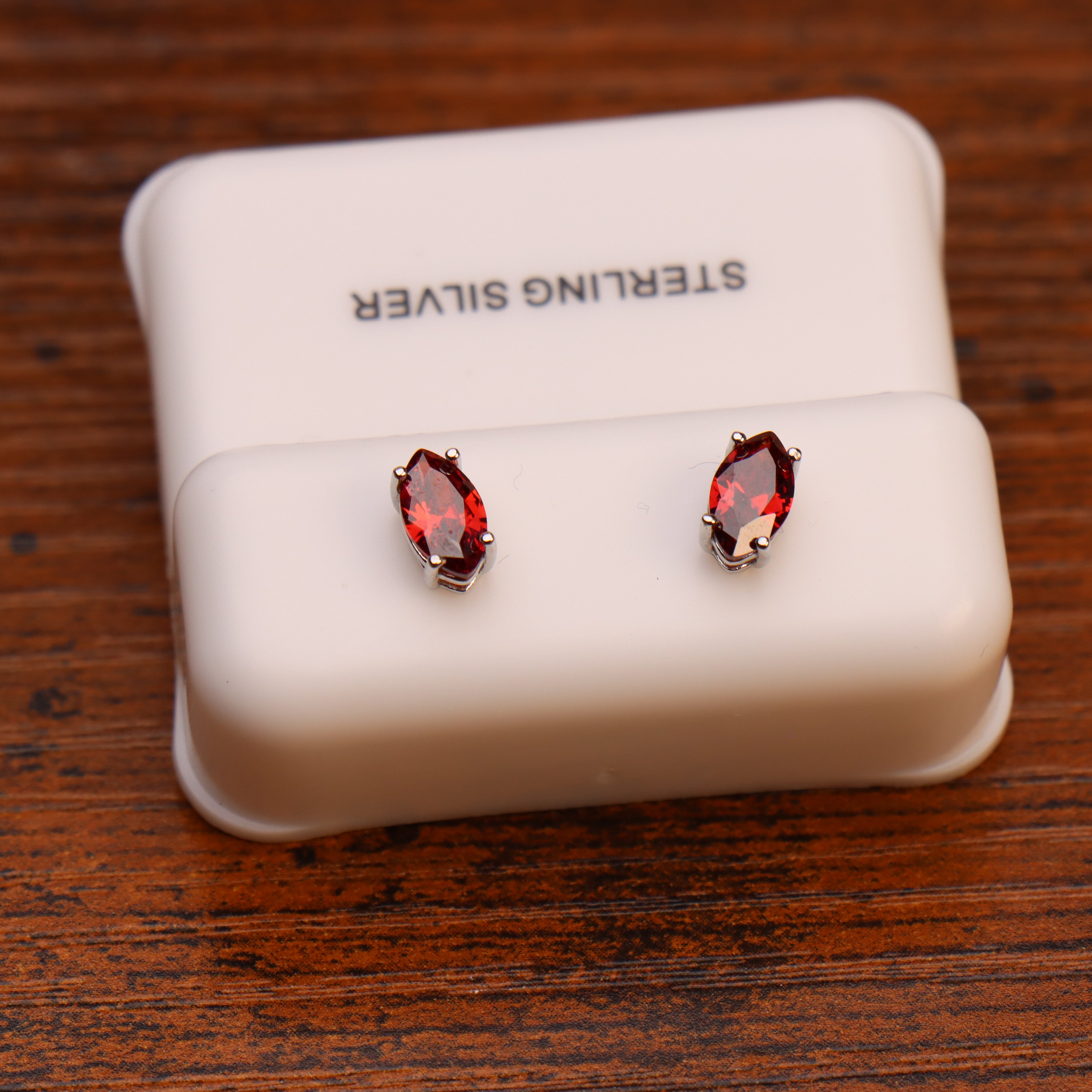 Marquise cut garnet CZ earrings in 925 sterling silver on a white display stand