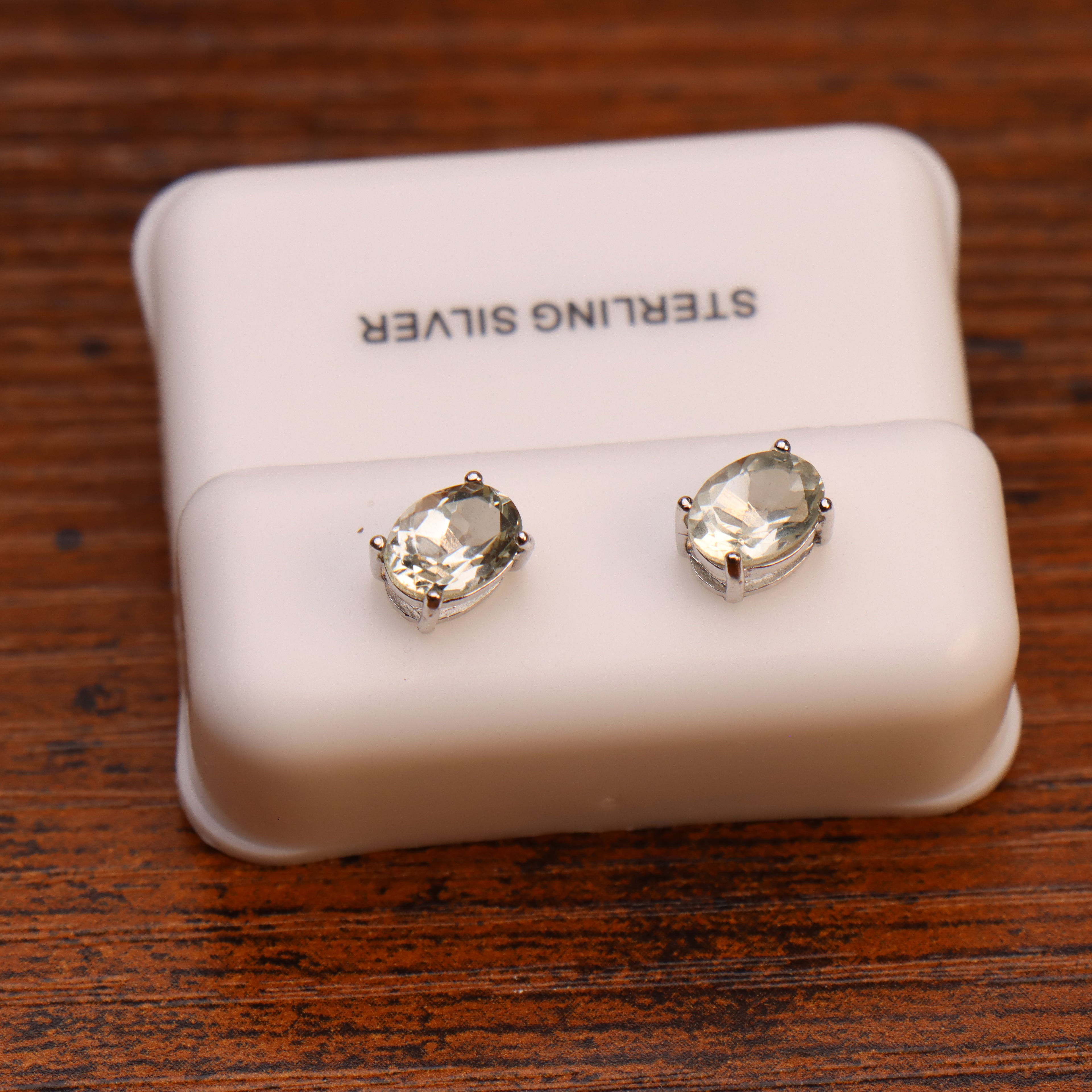 Green amethyst CZ oval earrings in 925 sterling silver on a white display stand