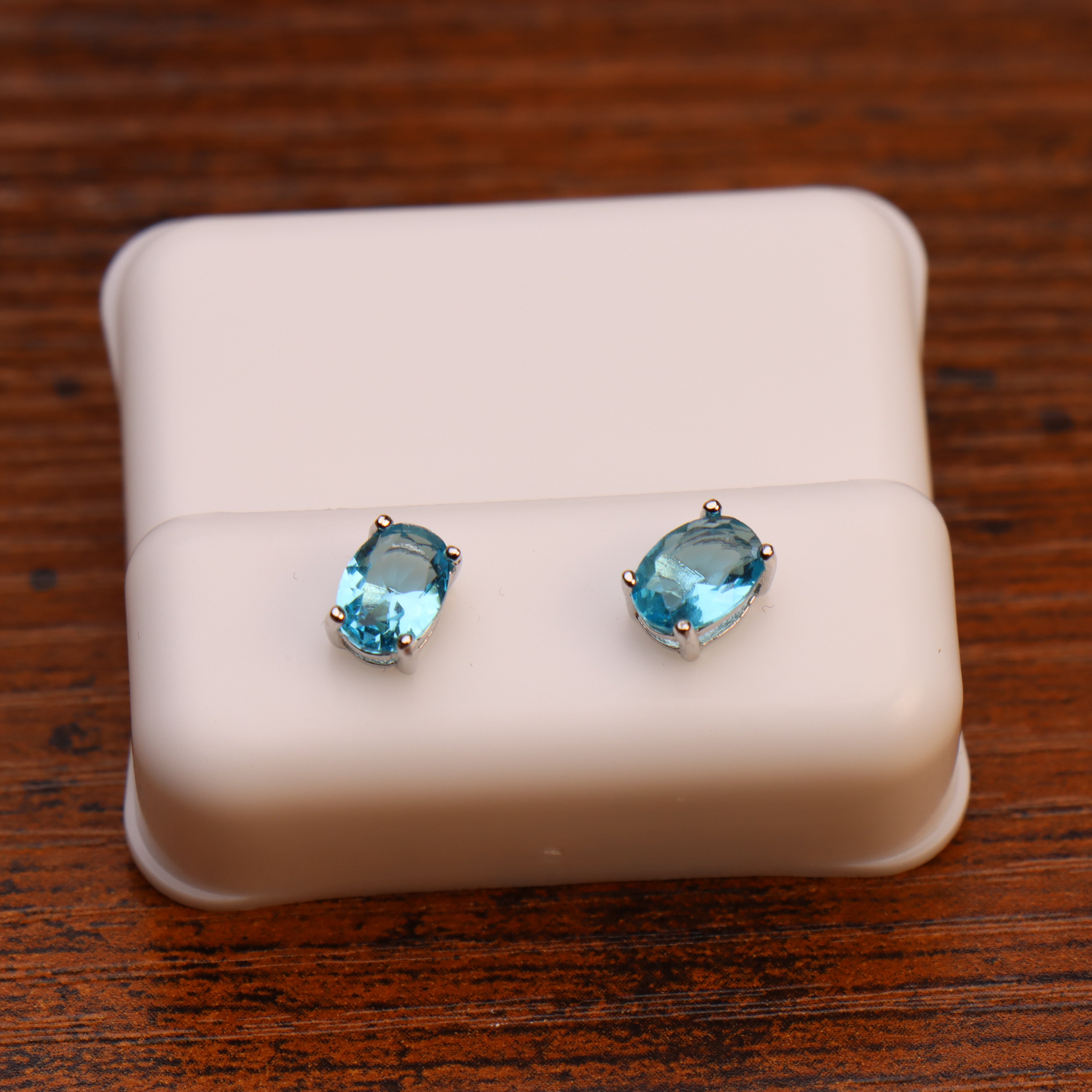 Baby blue oval cubic zirconia stud earrings in 925 sterling silver on a white display stand