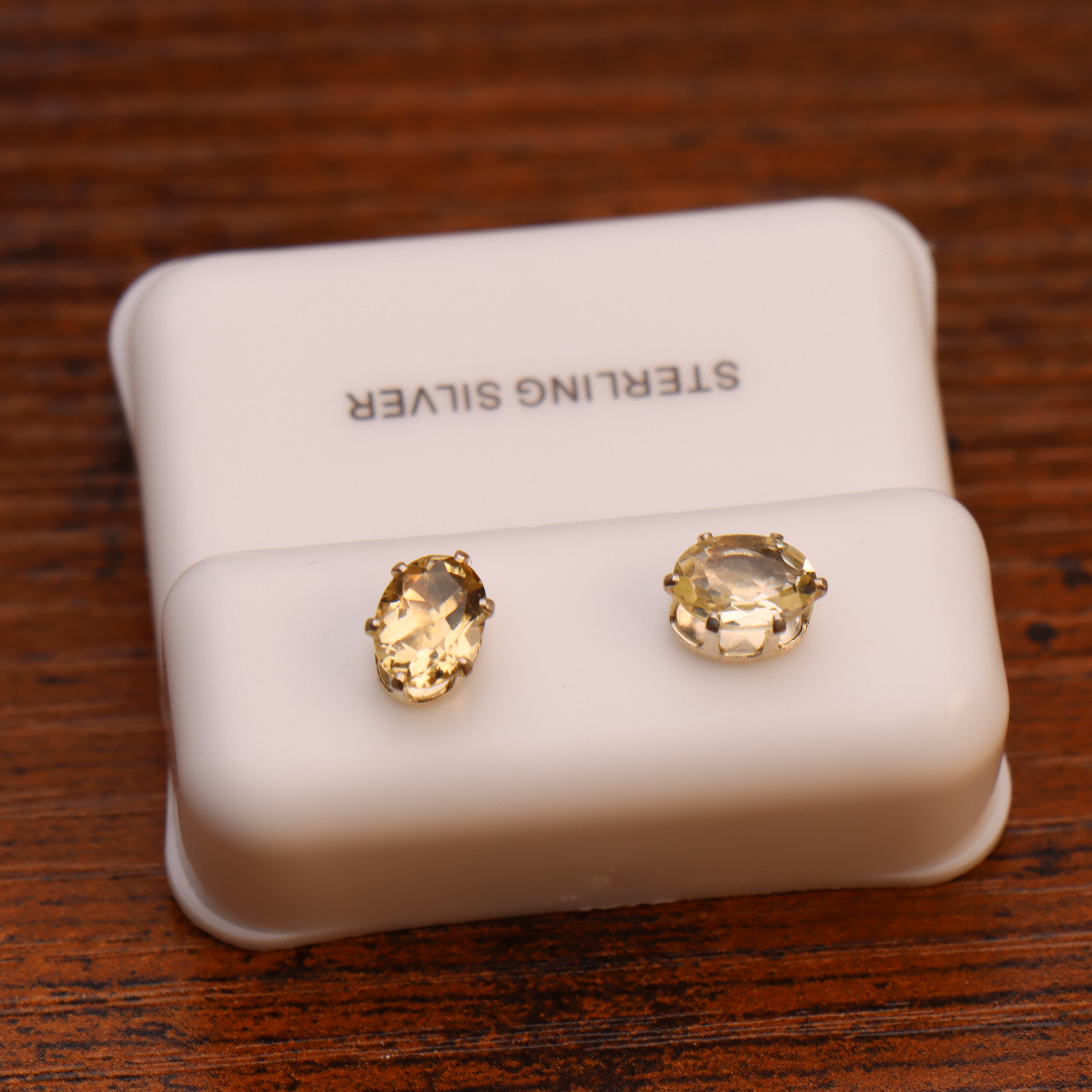 Oval citrine yellow CZ earrings in 925 sterling silver 5x7mm on a white display stand