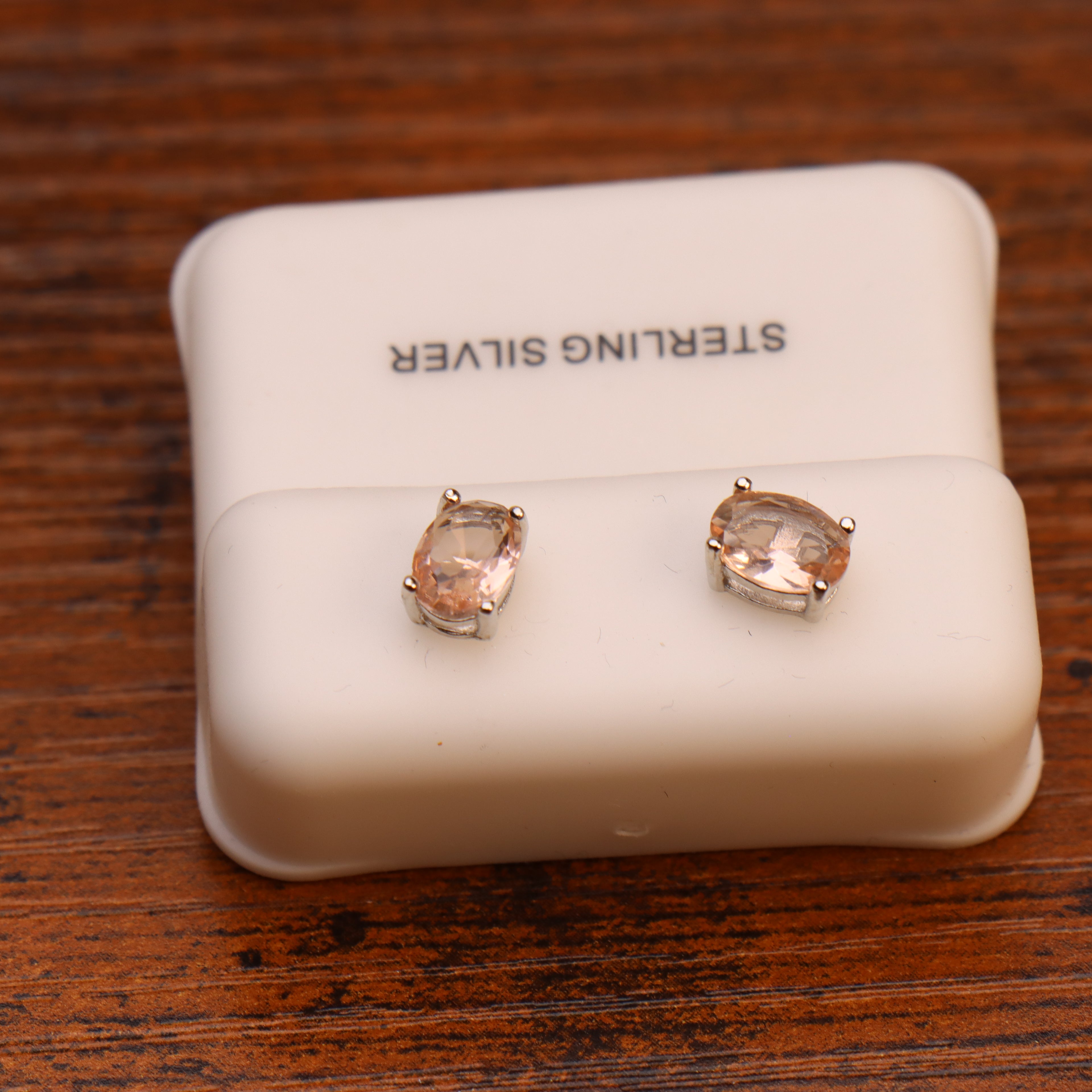 Morganite CZ oval stud earrings in 925 sterling silver on a white display stand