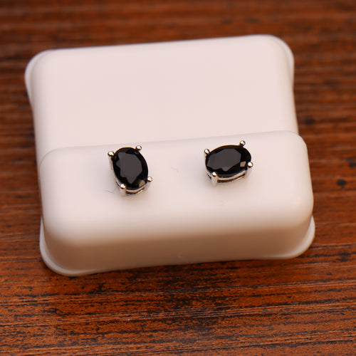 Oval black CZ earrings in 925 sterling silver 5x7mm on a white display stand