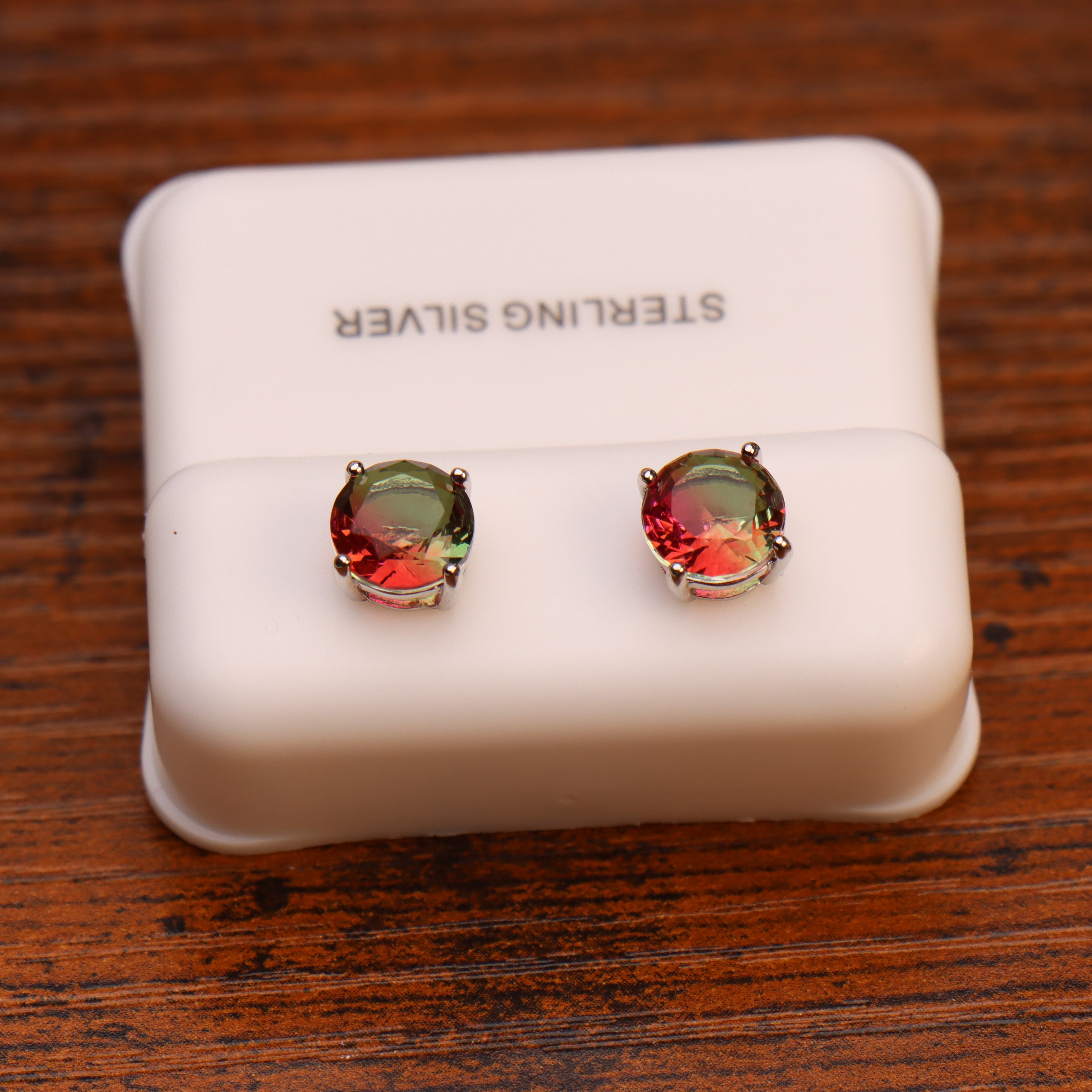 Round 7mm watermelon red and green cz earrings in 925 sterling silver on a white display stand