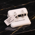 A pair of sterling silver rings displayed on a white jewelry stand, with a paper tag reading 'Sterling Silver Moissanite 0.62CT MSRP $329.