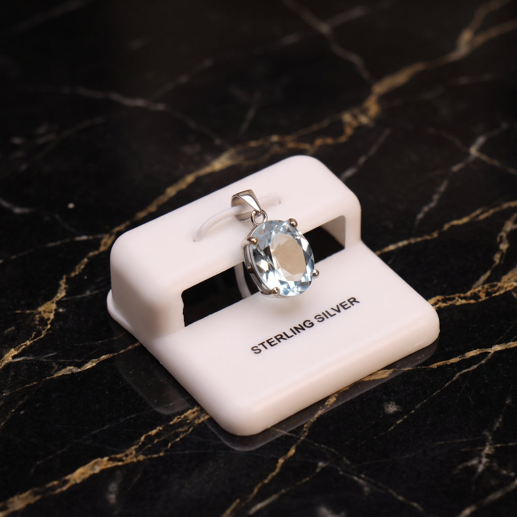 Blue topaz oval semi precious natural pendant in 925 sterling silver on a white display stand