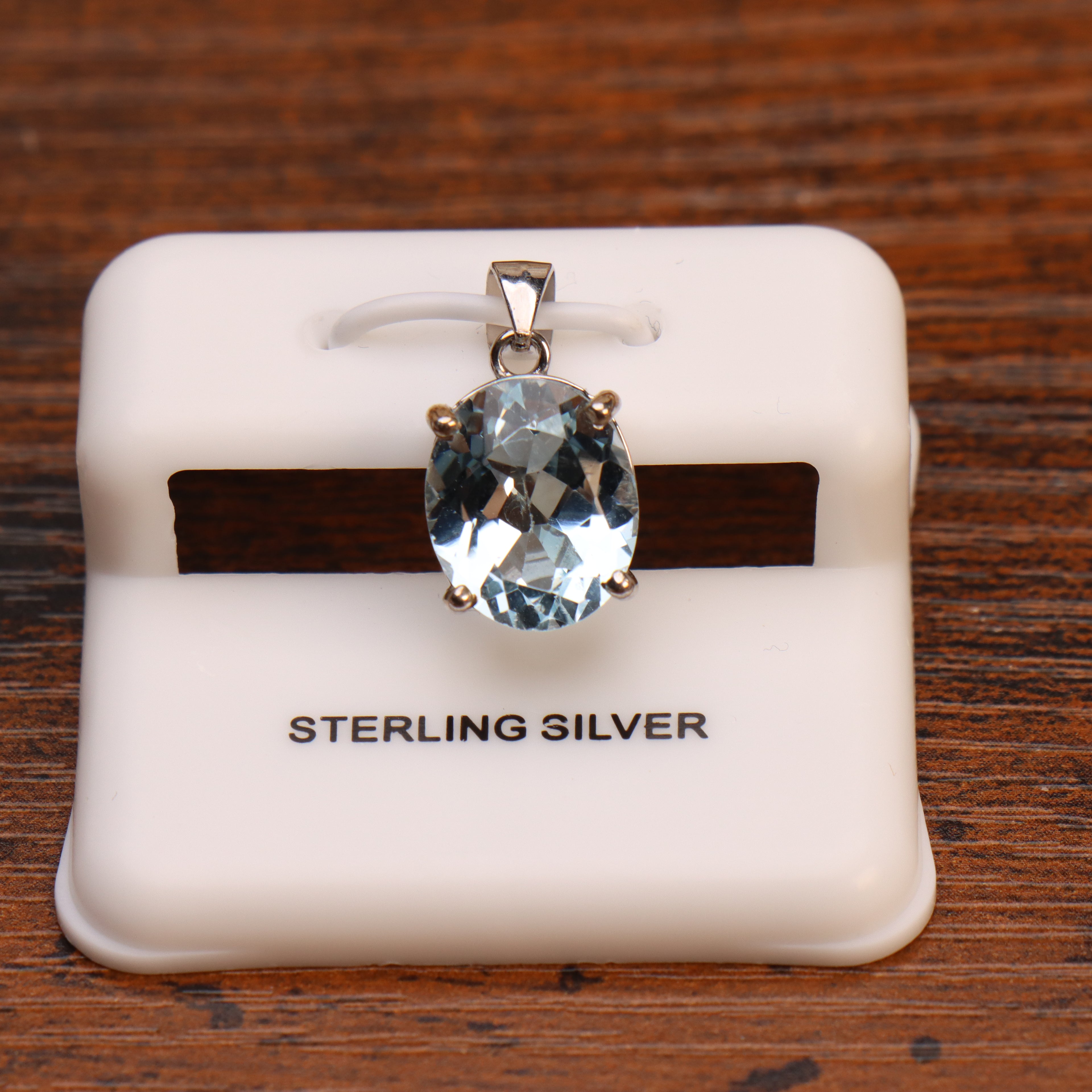 Blue topaz oval pendant in 925 sterling silver on a white display stand