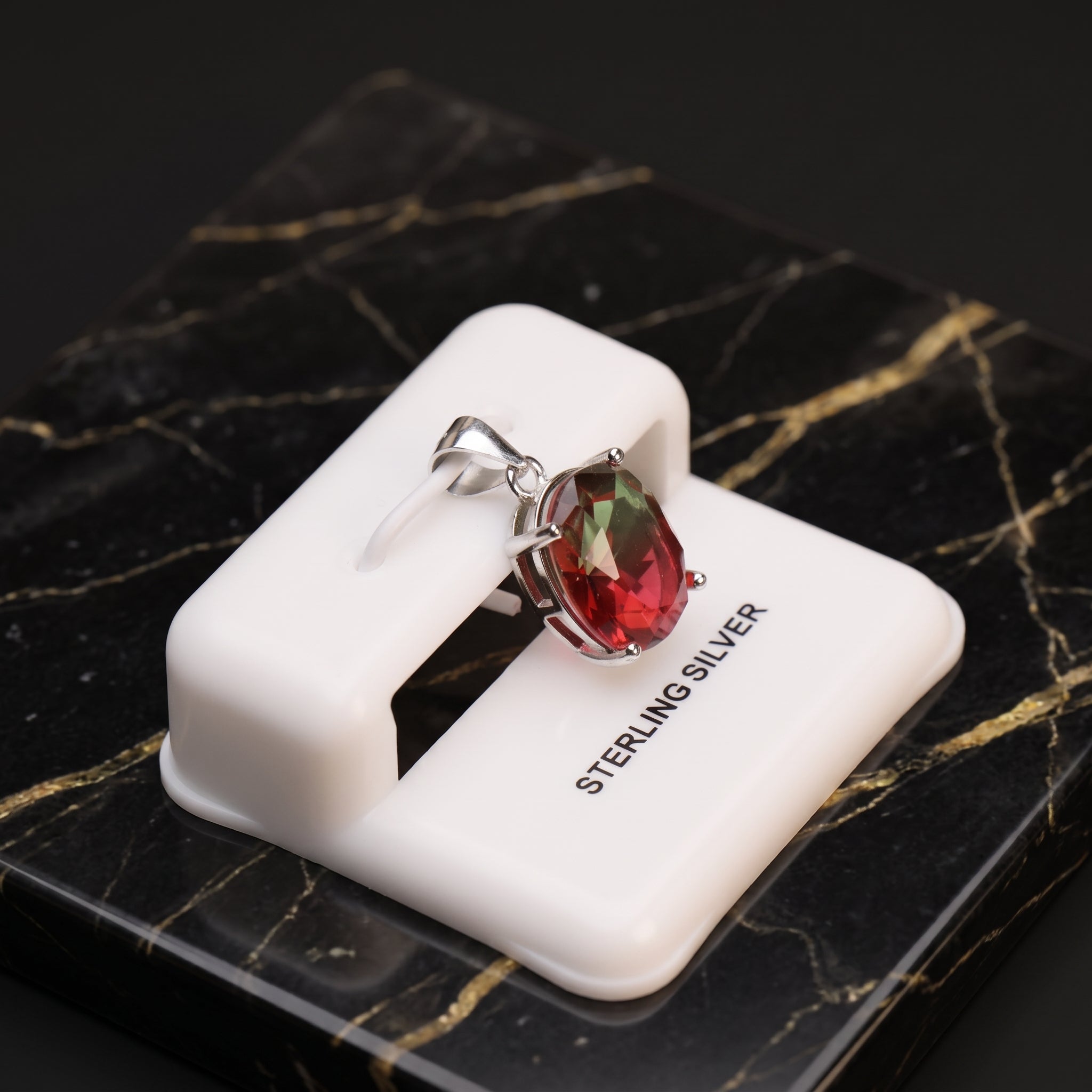 Watermelon oval semi precious natural pendant in 925 sterling silver on a white display stand