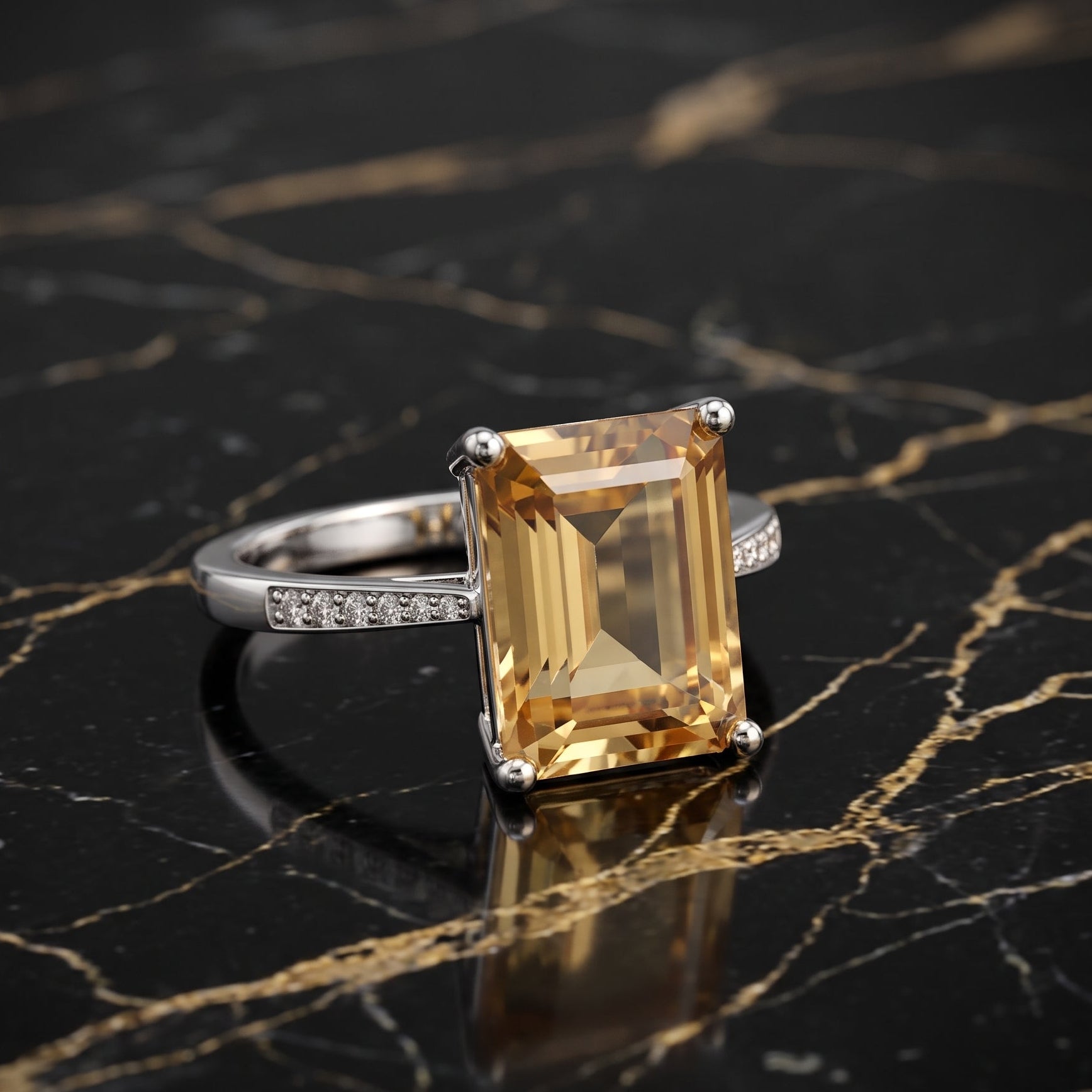 A silver ring featuring a large rectangular emerald-cut yellow gemstone, displayed on a black marble surface with gold veining. citrine