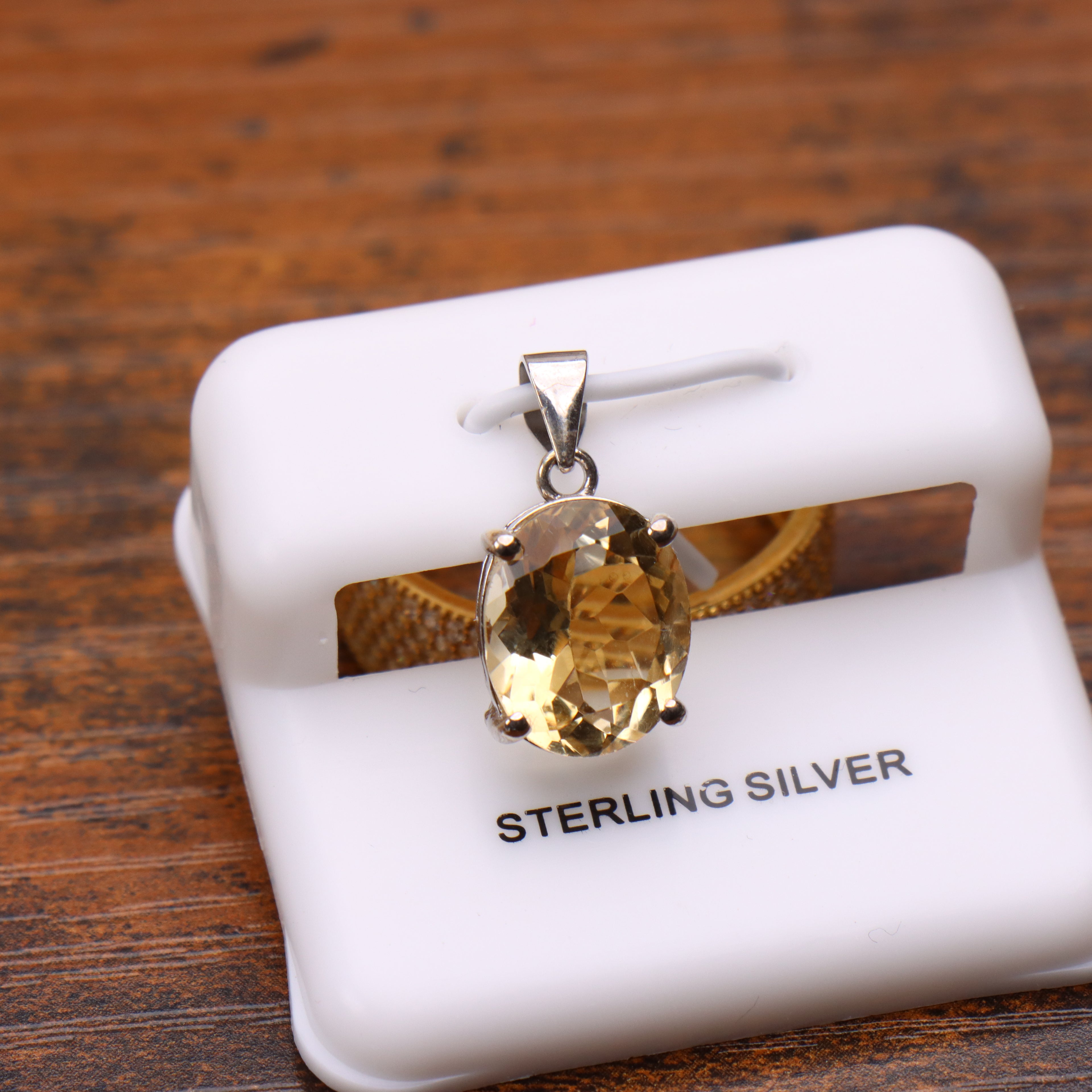 Citrine oval semi precious natural pendant in 925 sterling silver on a white display stand