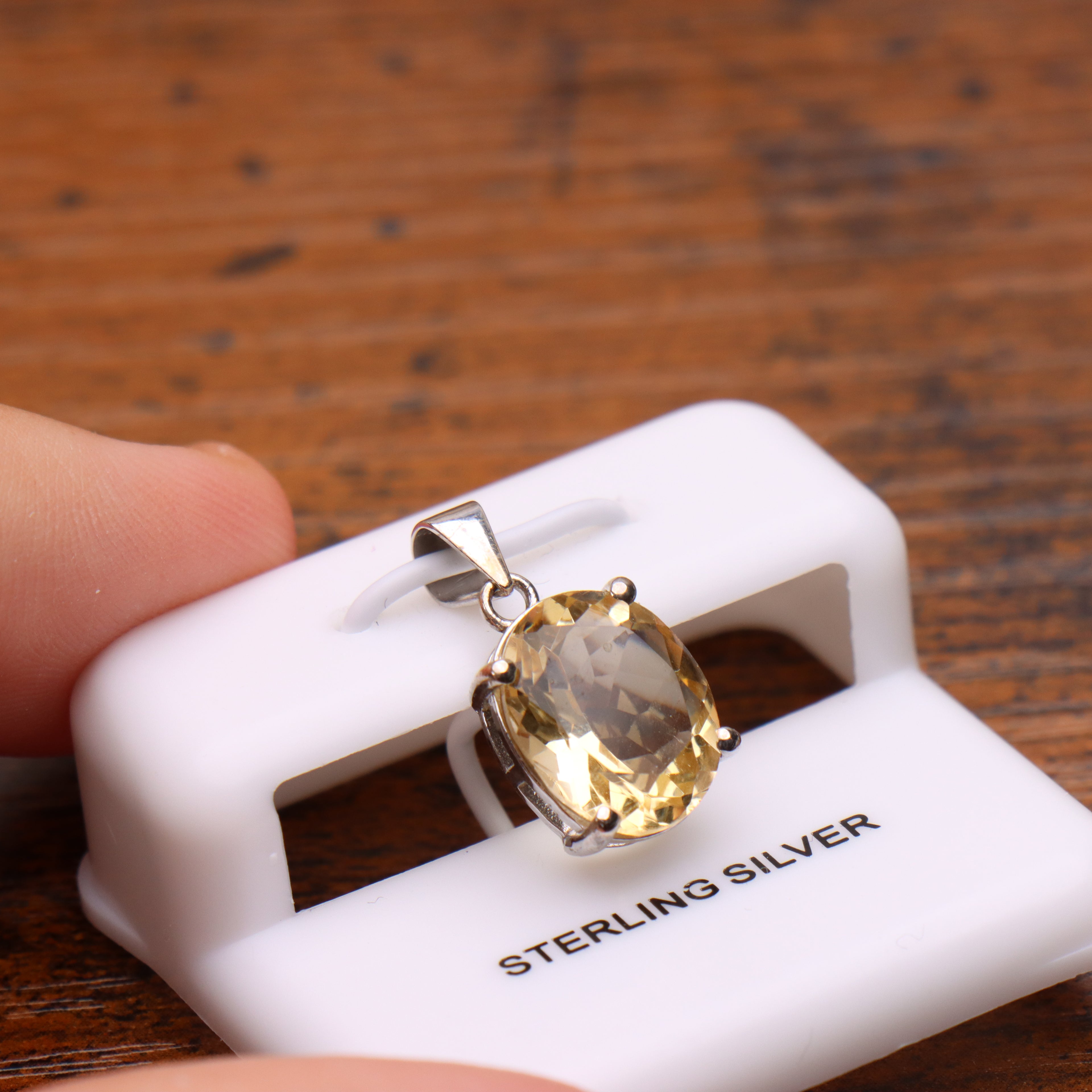 Citrine oval semi precious natural pendant in 925 sterling silver on a white display stand
