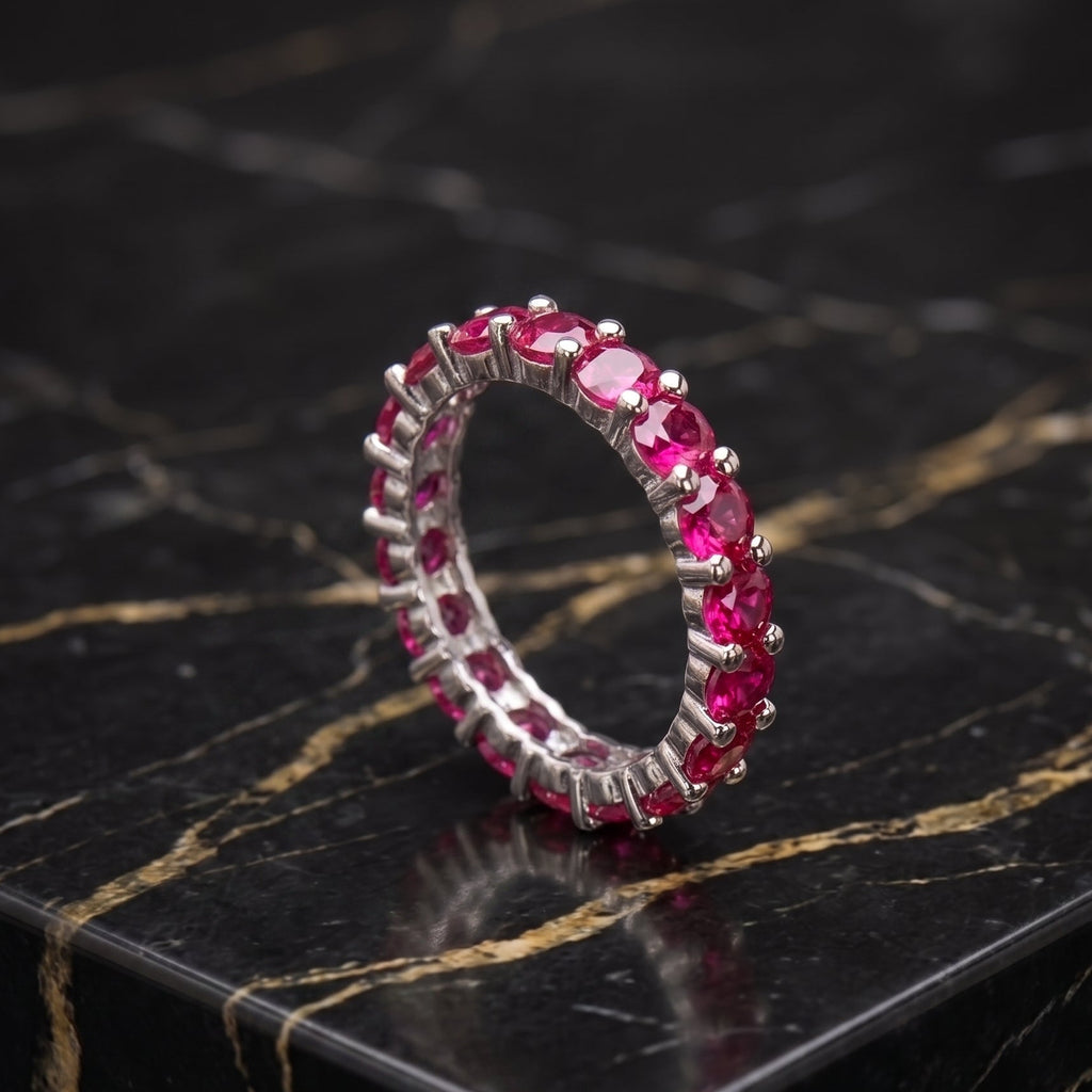 Magenta ruby eternity band ring in 925 sterling silver on a black marble surface